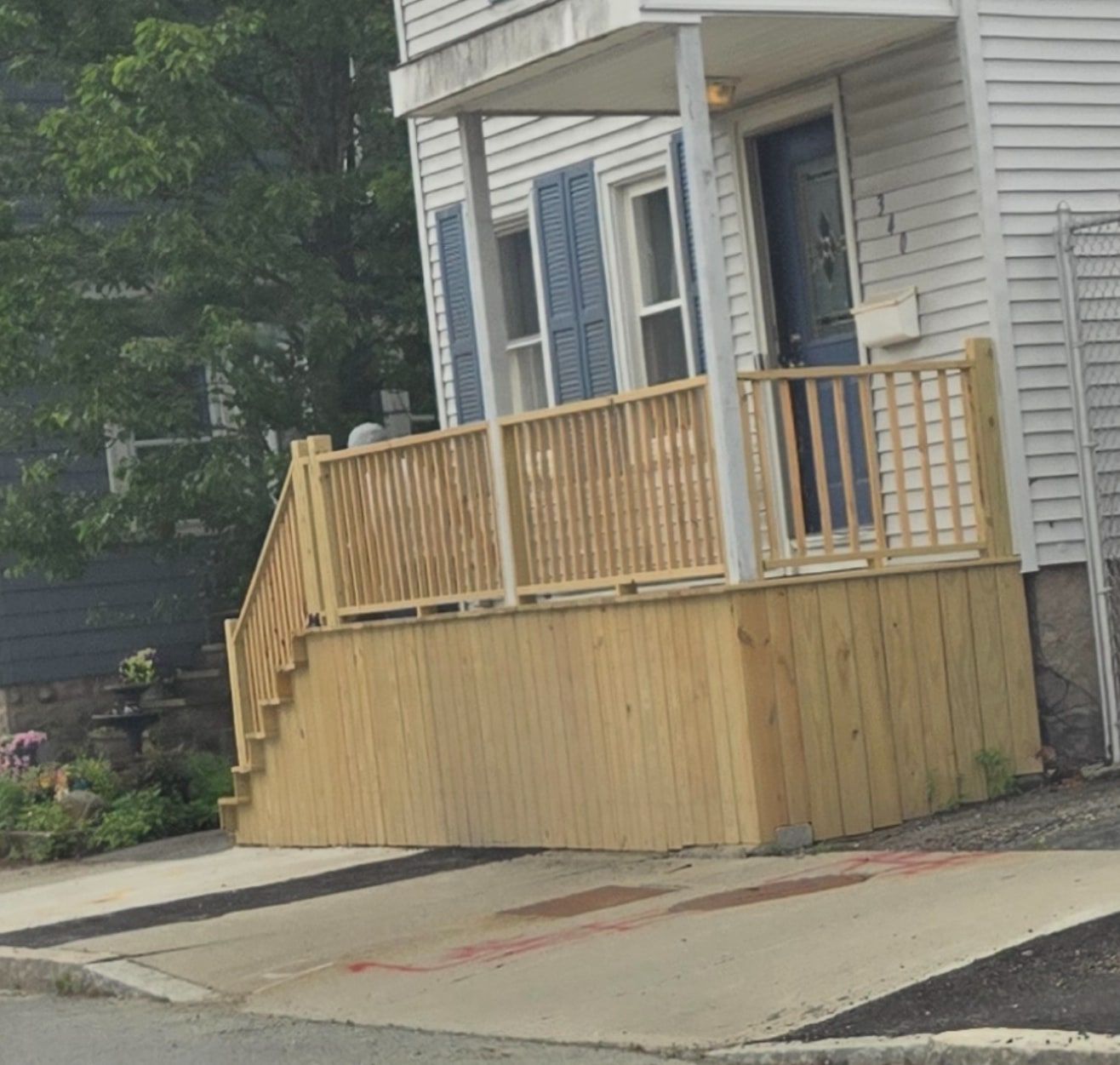 Rebuilt front porch with new wooden railings and stairs